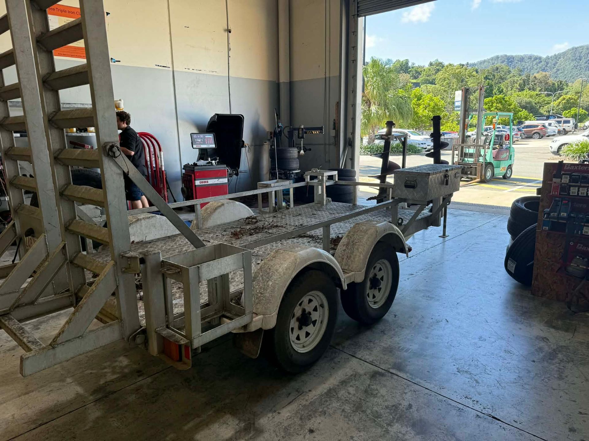 A Metal Tandem-axle Utility Trailer Parked Inside — Elite Fleet Auto - Electrics & Mechanical in Cannonvale, QLD