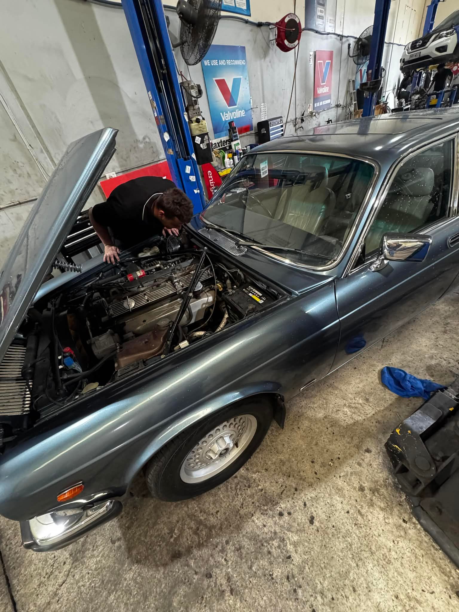 A Mechanic Leans Over The Open Engine Bay  — Elite Fleet Auto - Electrics & Mechanical in Rockhampton, QLD