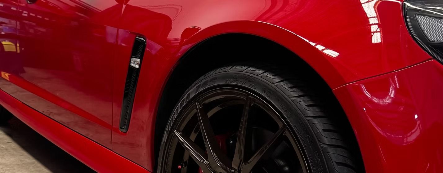 Red Car's Side, Showing Wheel, Black Trim, and Glossy Paint — Elite Fleet Auto - Electrics & Mechanical in Mackay, QLD