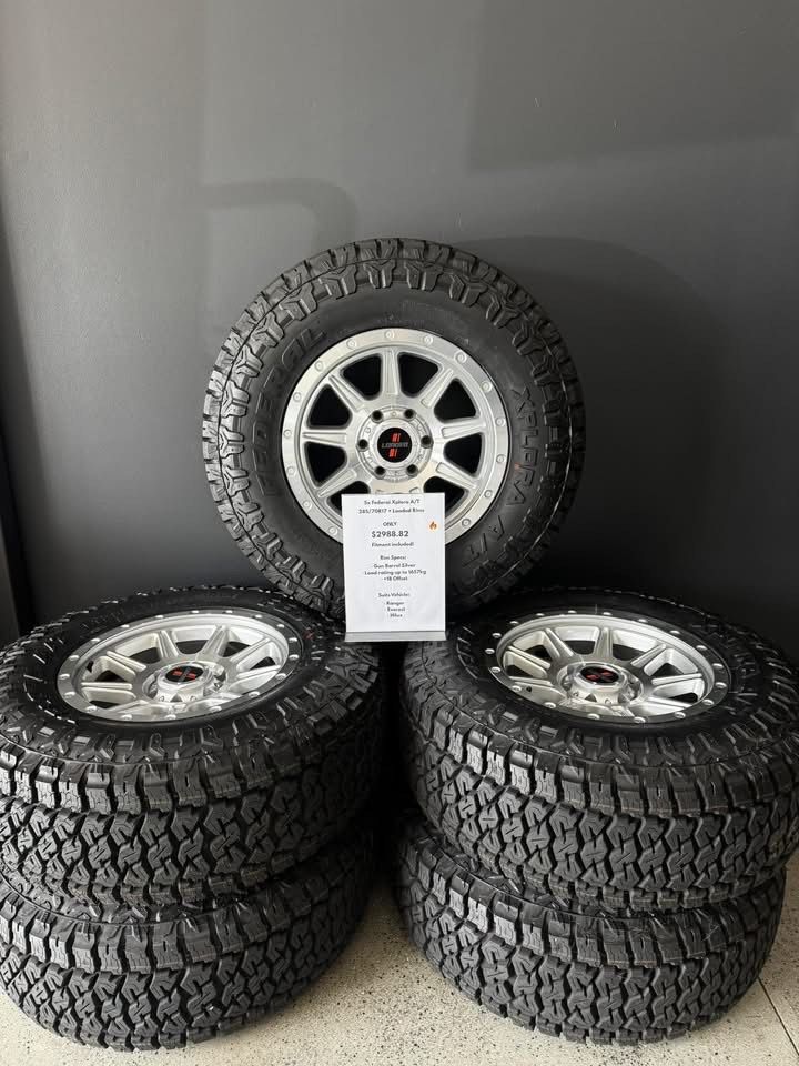 Four Off-road Tires With Silver Alloy Rims Stacked — Elite Fleet Auto - Electrics & Mechanical in Cannonvale, QLD