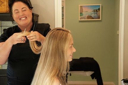 Hair dresser cutting a client’s hair at Enhance salon, Makarau, Rodney, Auckland