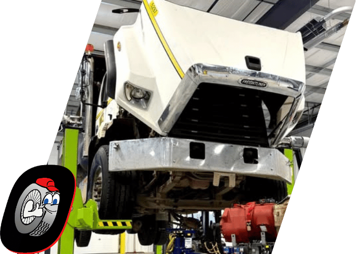 Commercial truck lifted in a service bay for heavy duty maintenance and repair.
