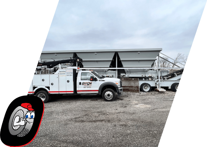 Utility service truck parked beside heavy industrial equipment at a commercial job site.