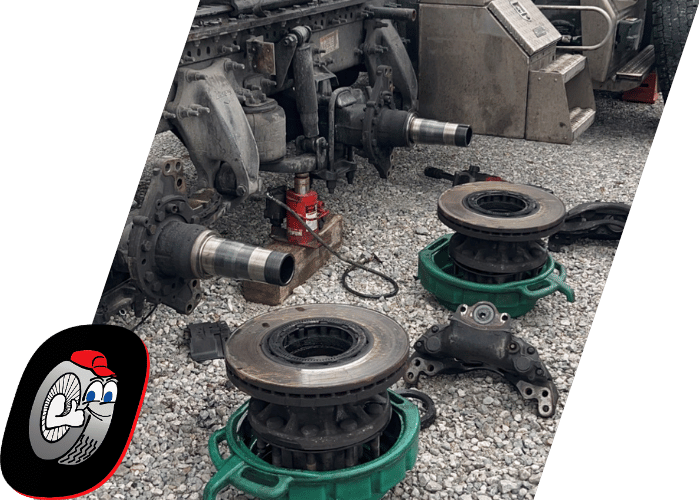 Heavy duty truck axle and brake components removed during commercial truck repair.