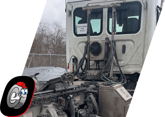 Rear section of a commercial truck equipped with hydraulic lines and fifth wheel components.
