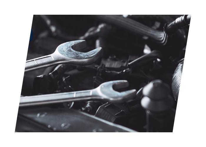 Open end wrenches resting on an engine during scheduled vehicle maintenance and repair.