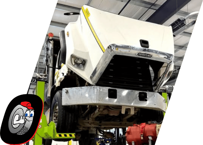 Technician performing welding and fabrication repairs on heavy duty commercial truck components.