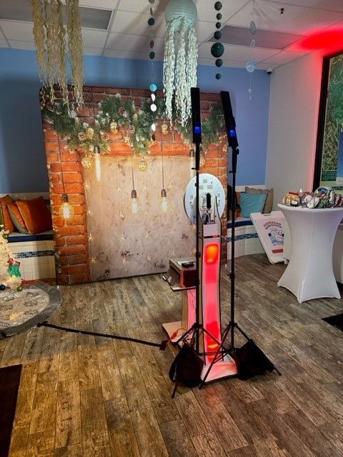 Decorated indoor event space with hanging lights, brick backdrop, and a glowing red tower centerpiece