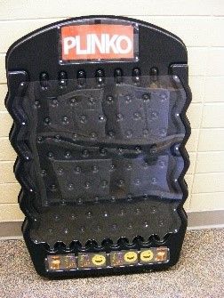 Black PLINKO game board with pegs and prize slots at the bottom