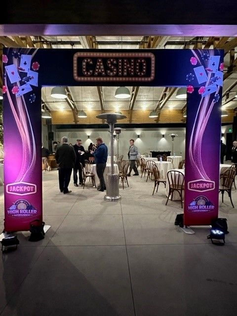Casino entrance under a purple-lit arch, with guests mingling inside at high-top tables.