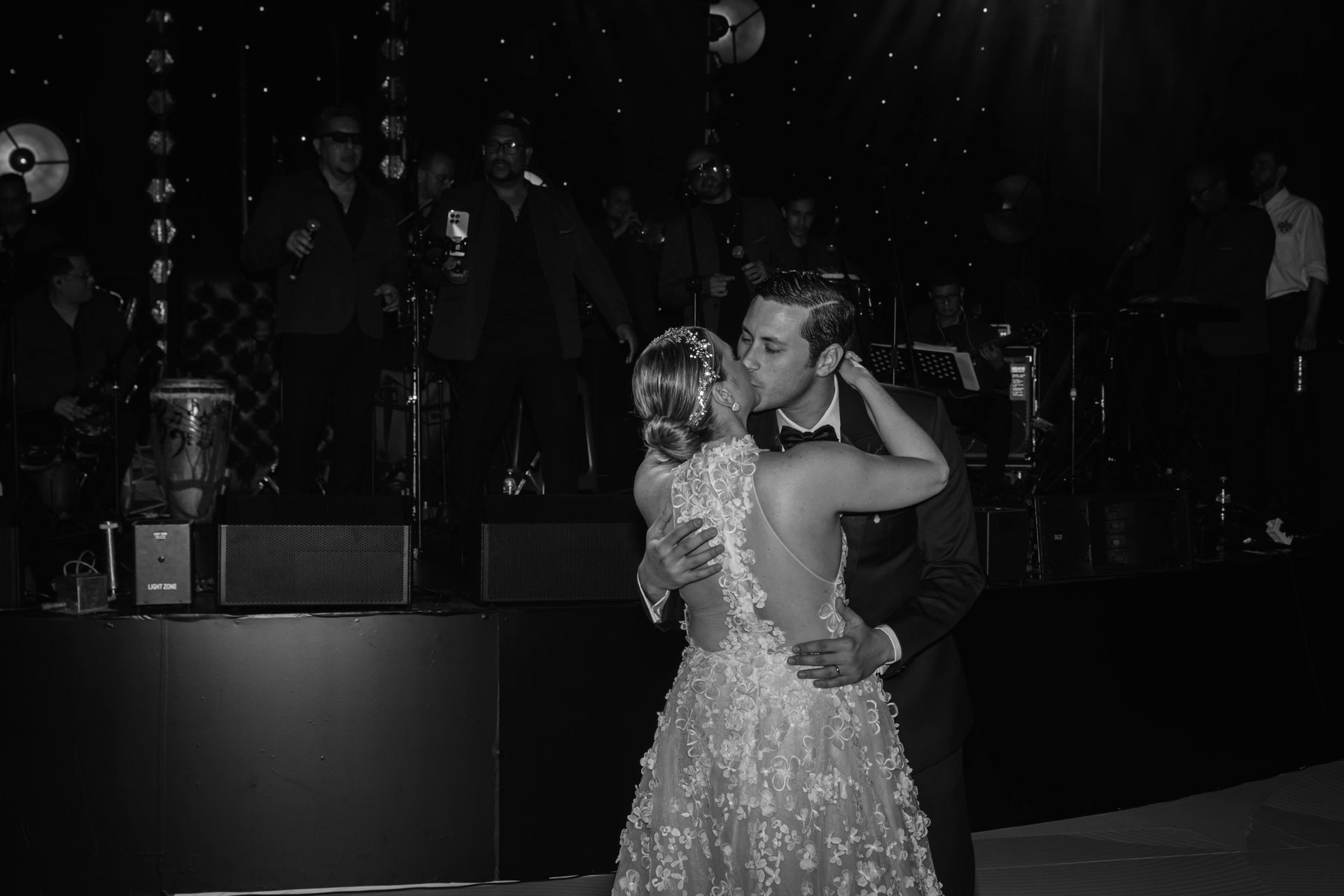 Bride and groom dancing on a dimly lit stage at a wedding reception