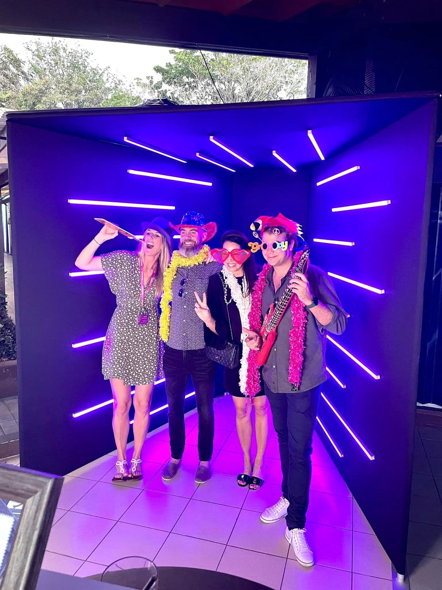 A group of people are posing for a picture in front of a vogue photo booth.