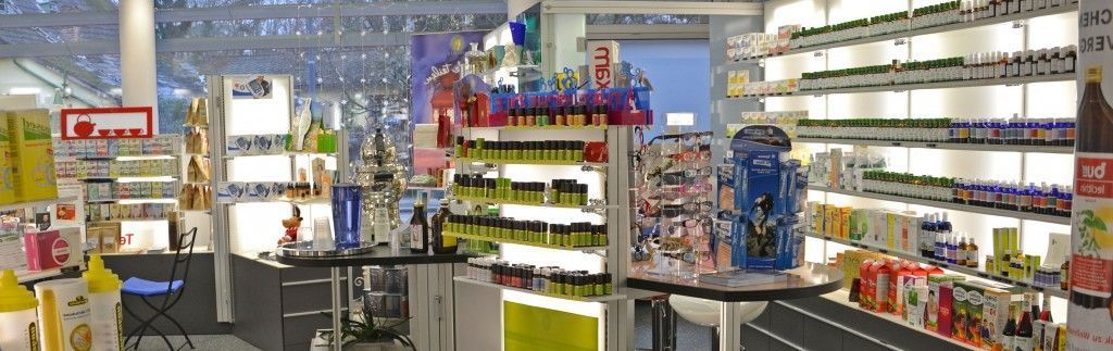 Ein heller Supermarktgang mit Regalen voller bunter Produkte und einem Einkaufswagen im Vordergrund