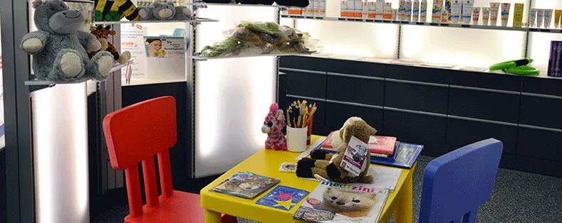 Ein Kinderspieltisch mit bunten Stühlen und Spielzeug in einer gemütlichen Ecke im Haus.