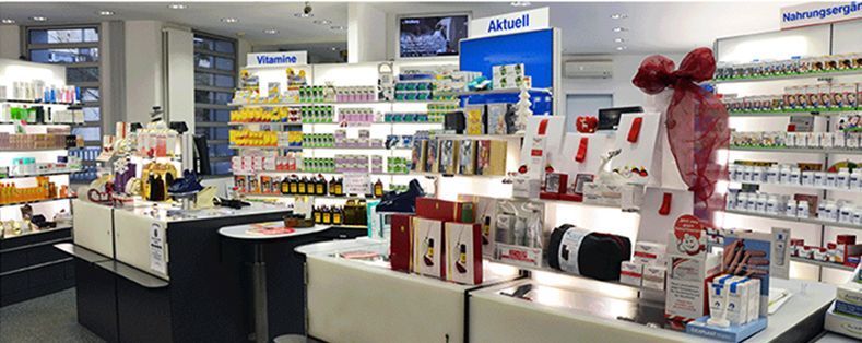 Kosmetiktheke mit Regalen voller Schönheitsprodukte und einer Geschenkauslage in der Apotheke Rodaun