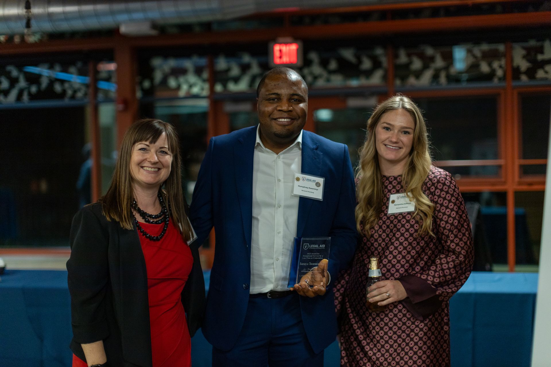 A photo of three people smiling and holding an award at the 2025 Journey Toward Justice Reception