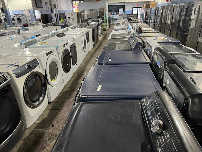 A large room filled with lots of washing machines and dryers.
