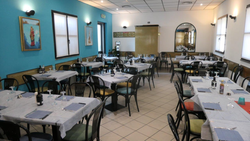 Un ristorante con tavoli e sedie e una parete blu