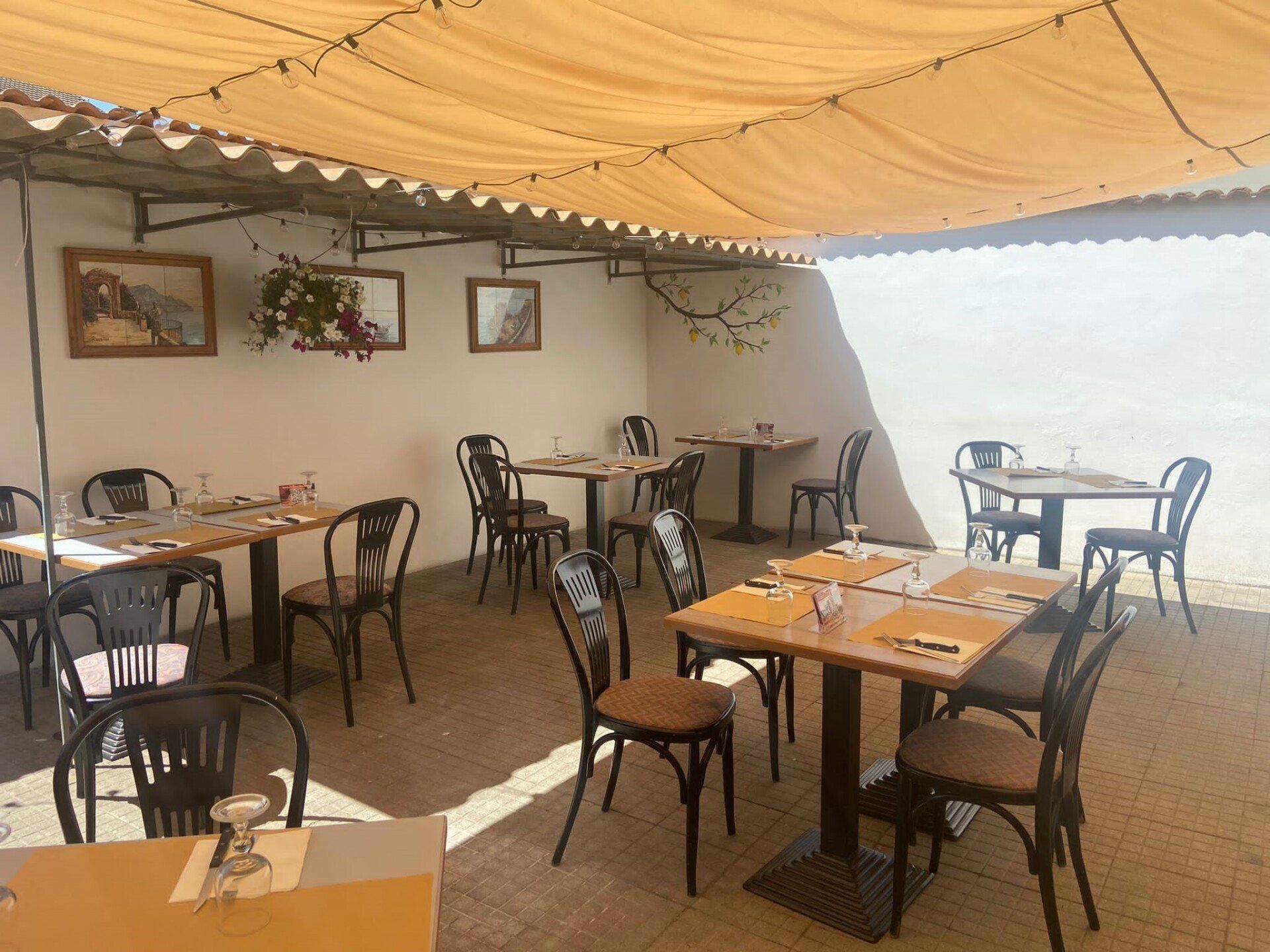 Un ristorante con tavoli e sedie sotto una tettoia.