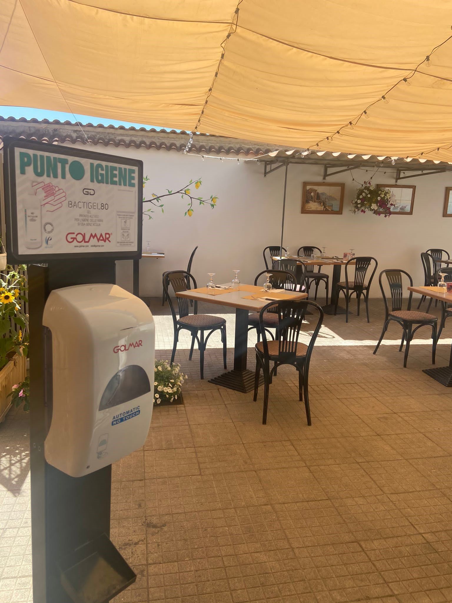 Un ristorante con tavoli e sedie e un cartello che dice punto igiene