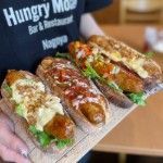 Hotdogs Thumbnail - a picture of staff holding a tray of gourmet hotdogs