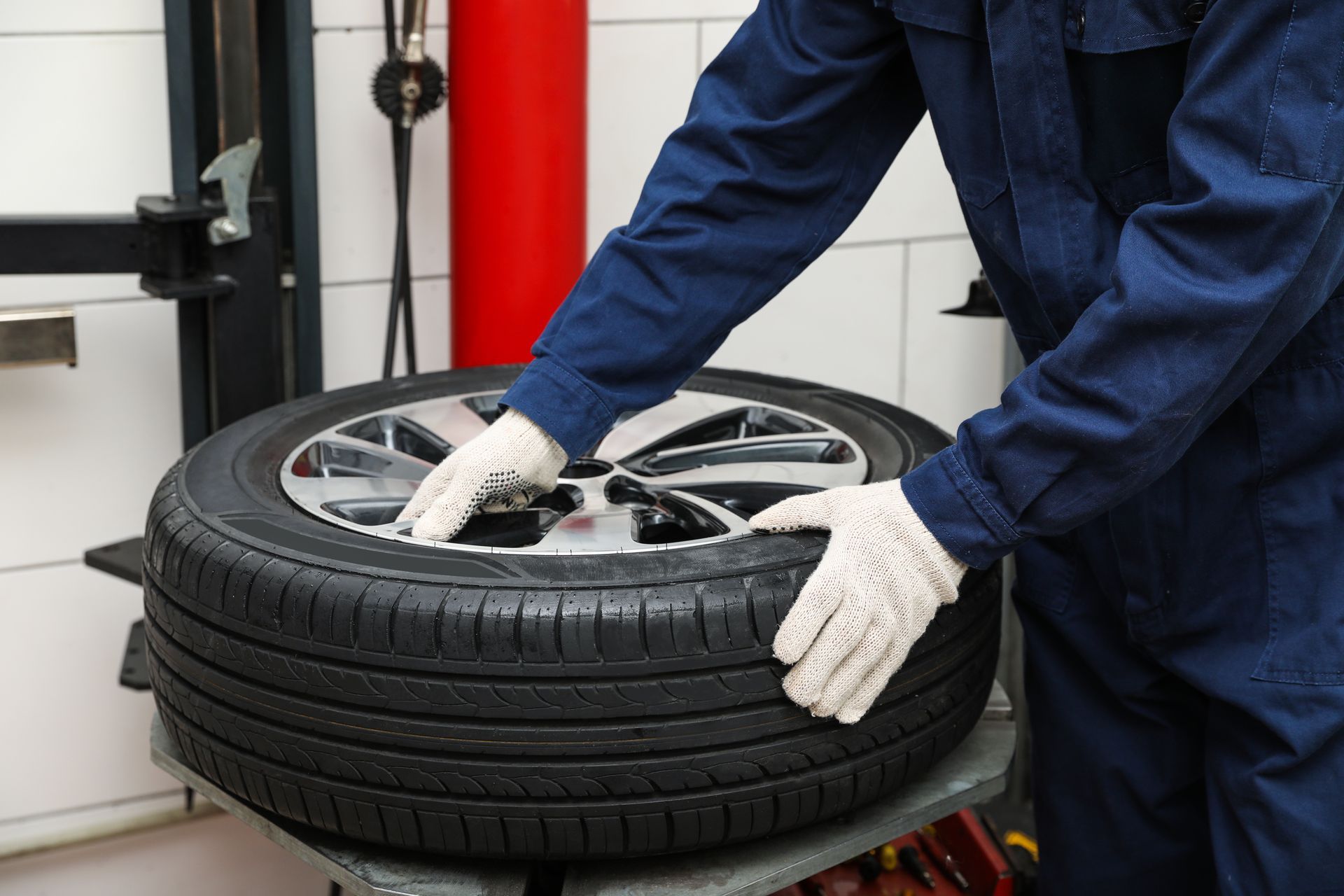 A mechanic is working with a tyre mounting and balancing.