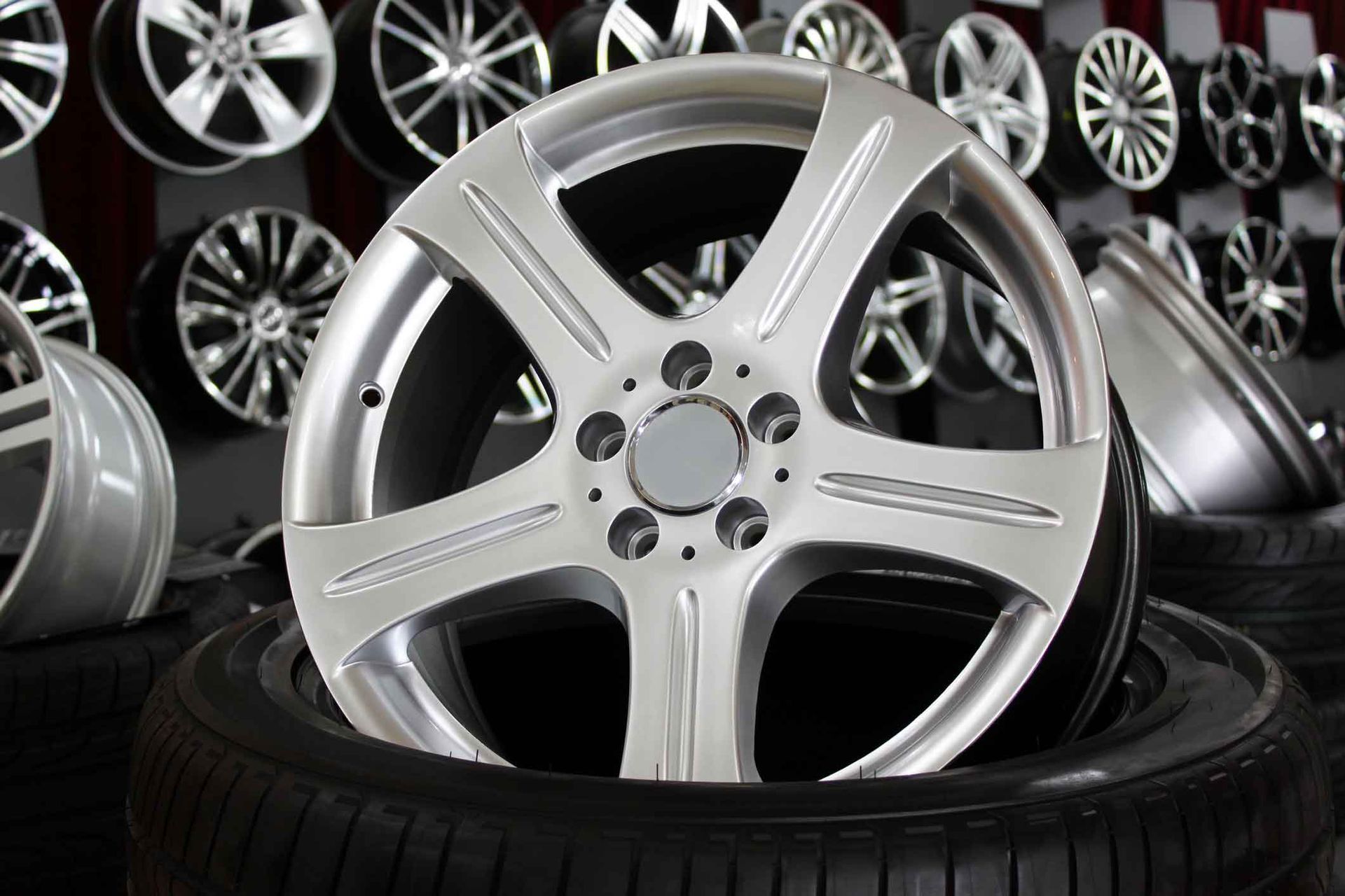 A car wheel is sitting on top of a tire in a store.