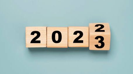 The year 2022 is written on wooden blocks on a blue background.