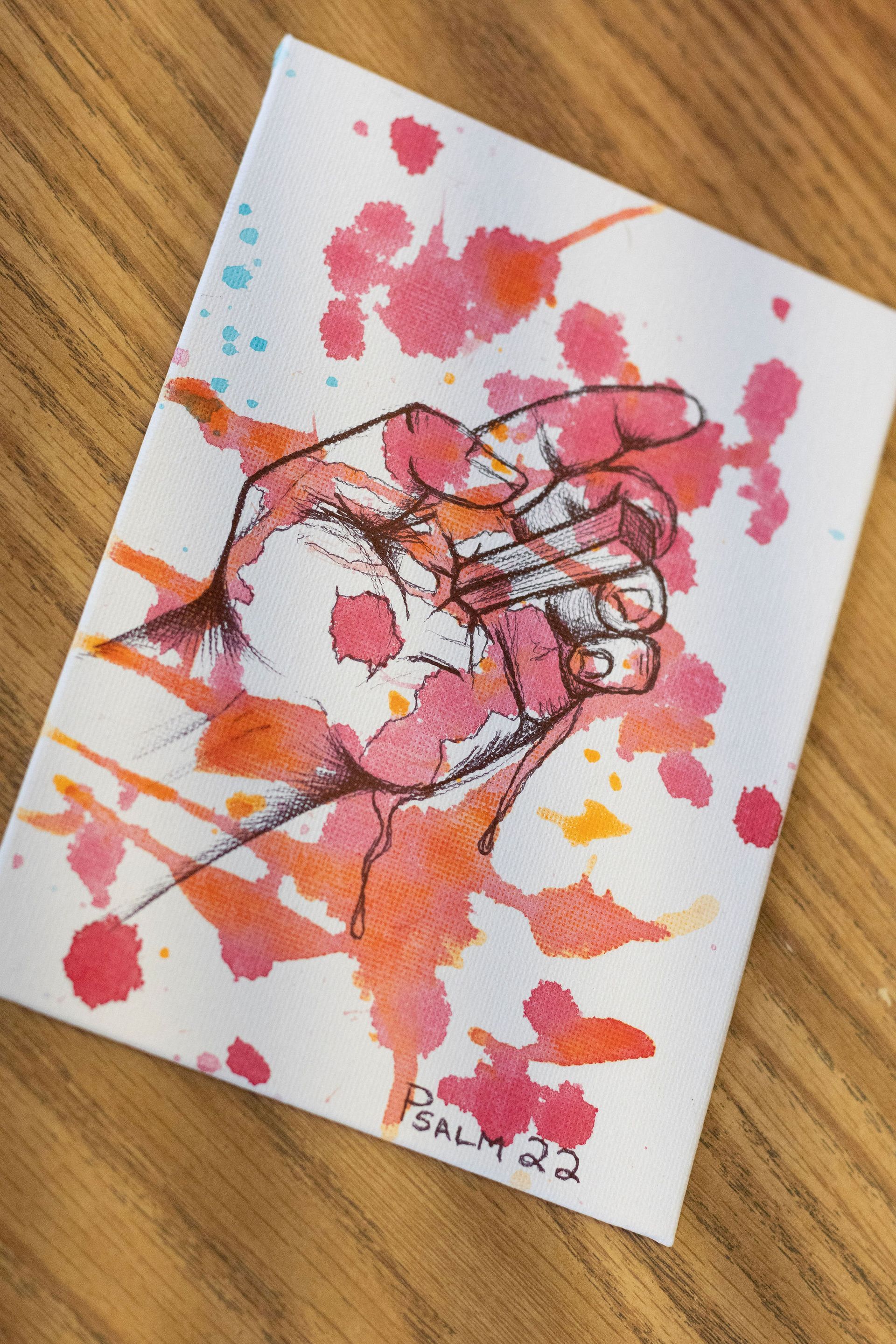 Hand in a fist, with watercolor splatters. Pink, orange, and blue. Signed 