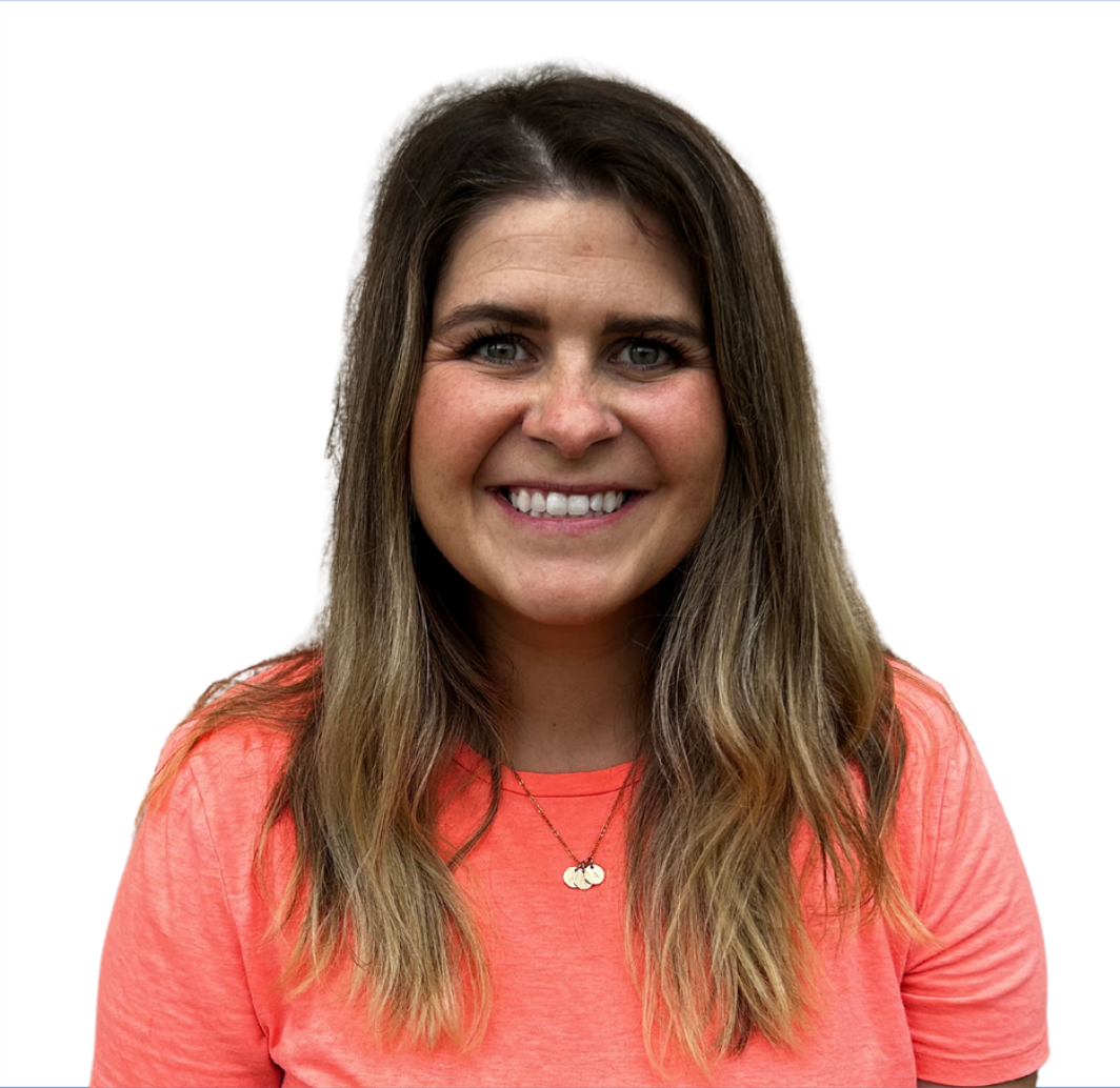 A woman wearing an orange shirt and a necklace is smiling for the camera.