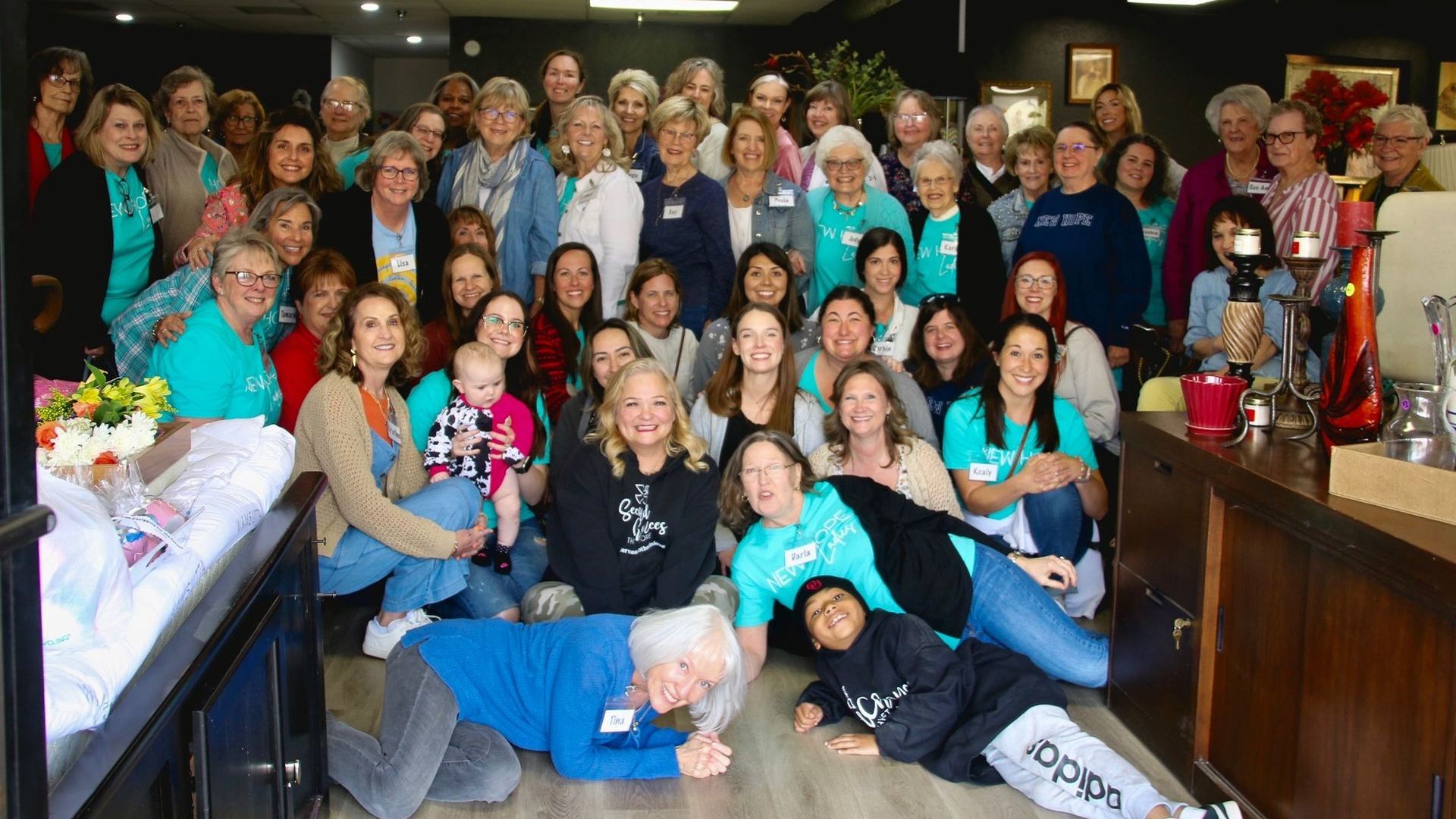 A large group of people are posing for a picture in a room.