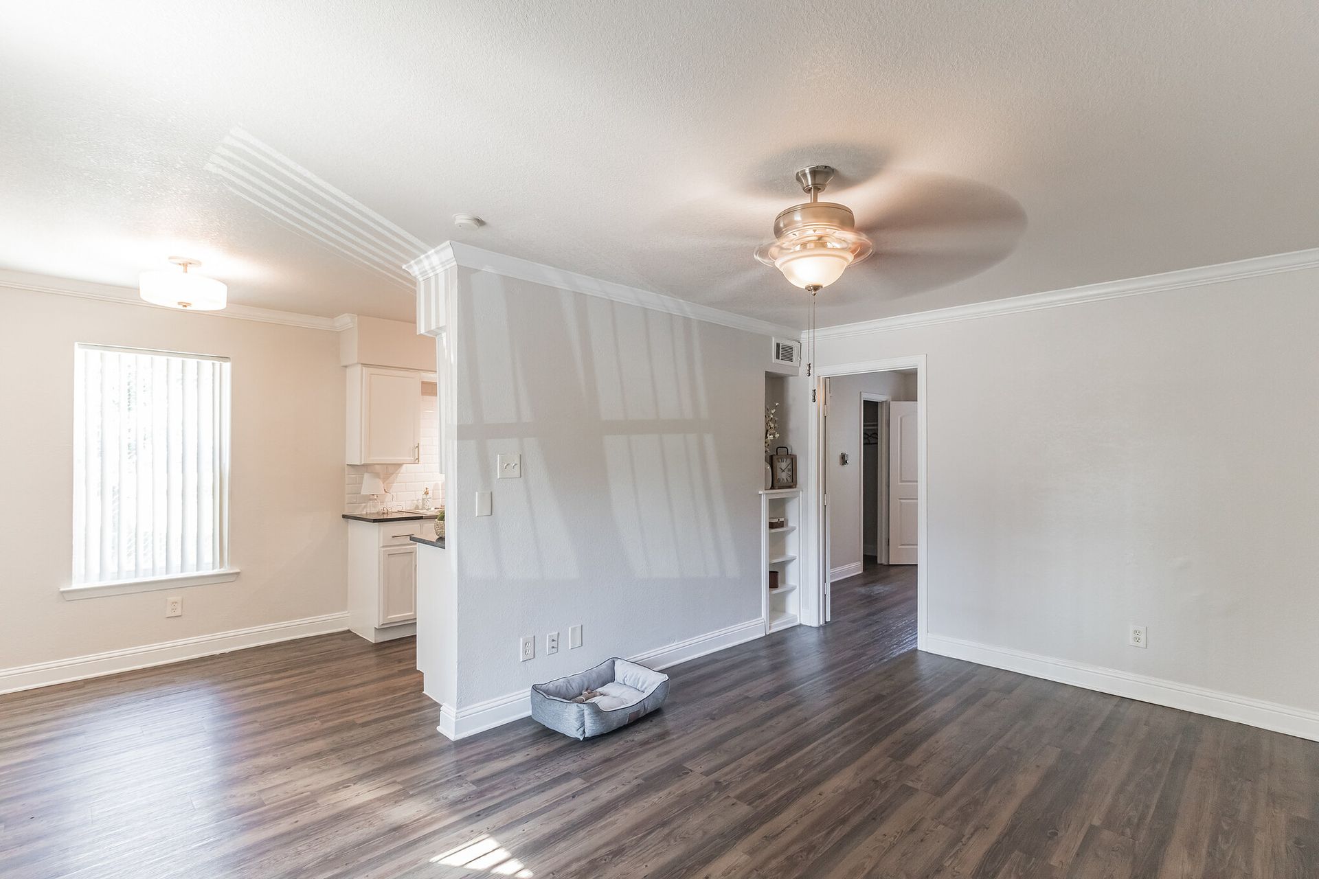 Photo of a living room with the kitchen and dining room in the background