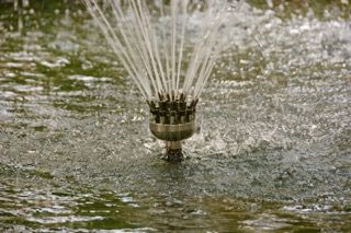 A lawn sprinkler spraying water across a wet grassy surface.