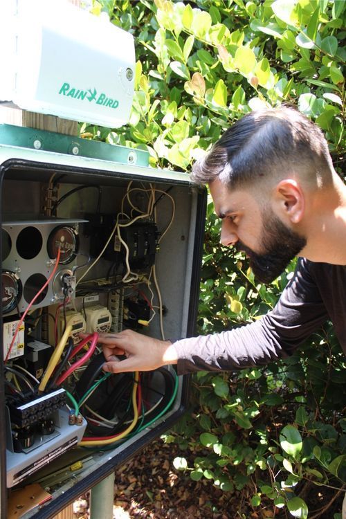 A technician adjusting the control panel for a lake water fountain.