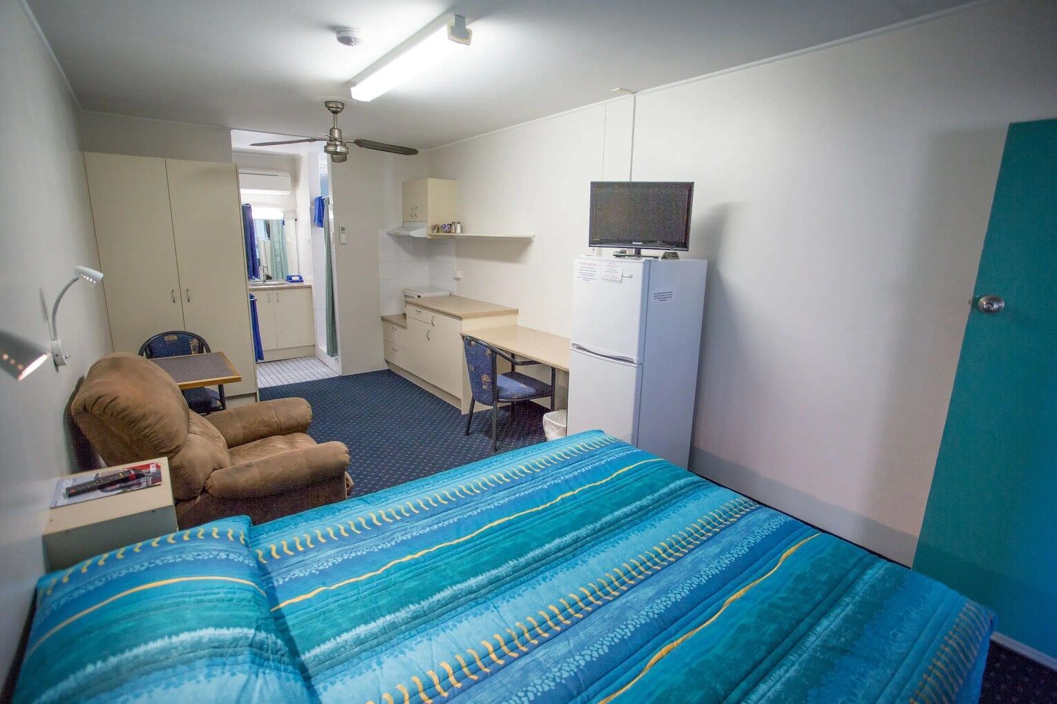 Small Motel Room With Bed, Kitchenette, Chair, Desk, and Tv — Fourth Avenue Motor Inn in Parkside, QLD