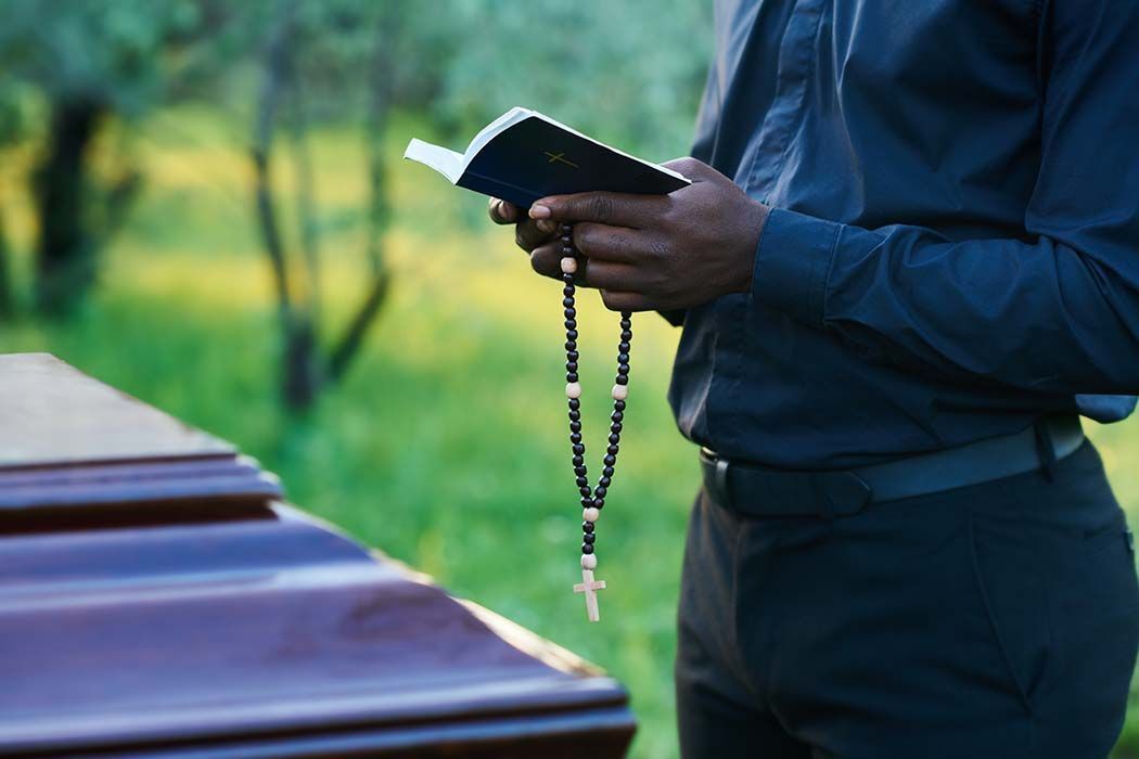A man is standing in front of an open bible in a church.