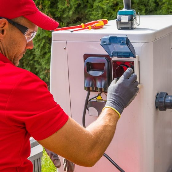 A man in a red shirt is working on a machine