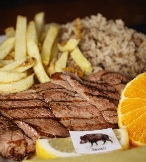 Bife grelhado com batatas fritas, arroz e fatias de laranja no prato.
