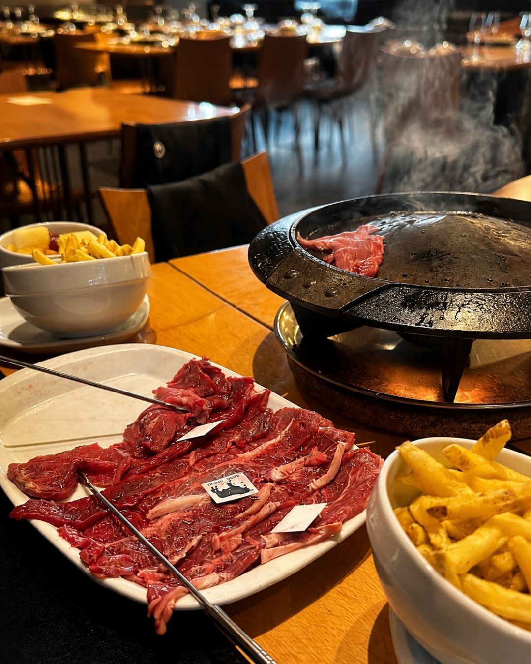 Copo de cerveja e aperitivos fritos com fatias de limão sobre uma mesa em um restaurante informal.