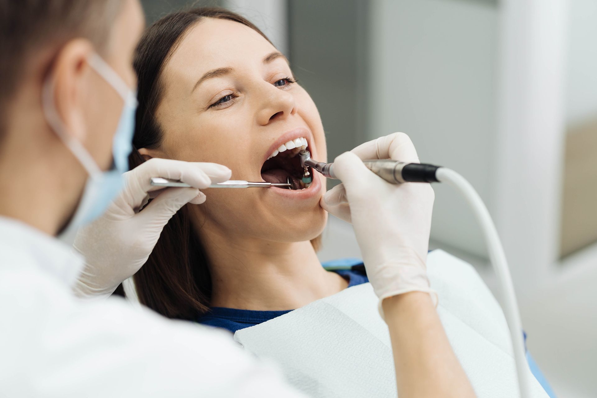 Un dentista esamina la bocca aperta di un paziente con strumenti odontoiatrici in una clinica.