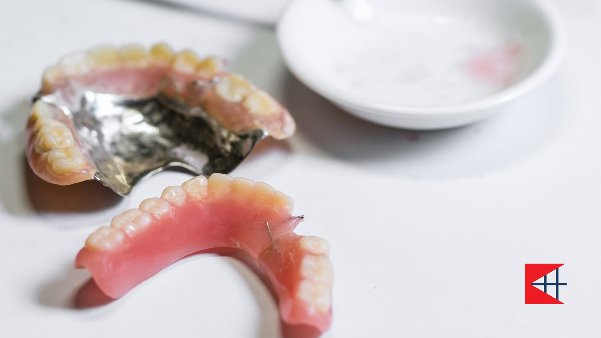 A denture is sitting on a table next to a bowl.