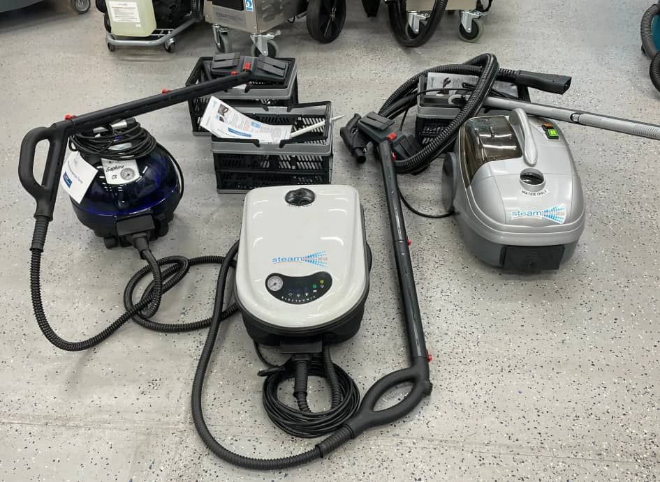 Three Vacuum Cleaners Are Sitting On The Floor In A Room — Springs Cleaning Supplies In Ciccone, NT