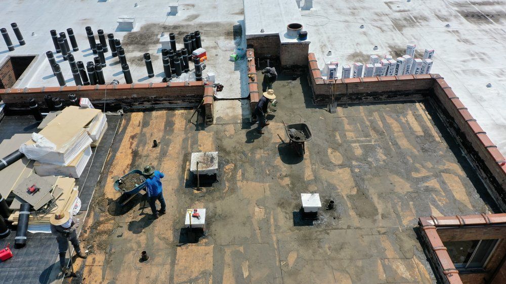 Construction site rooftop with workers, tools, and concrete walls under bright sunlight