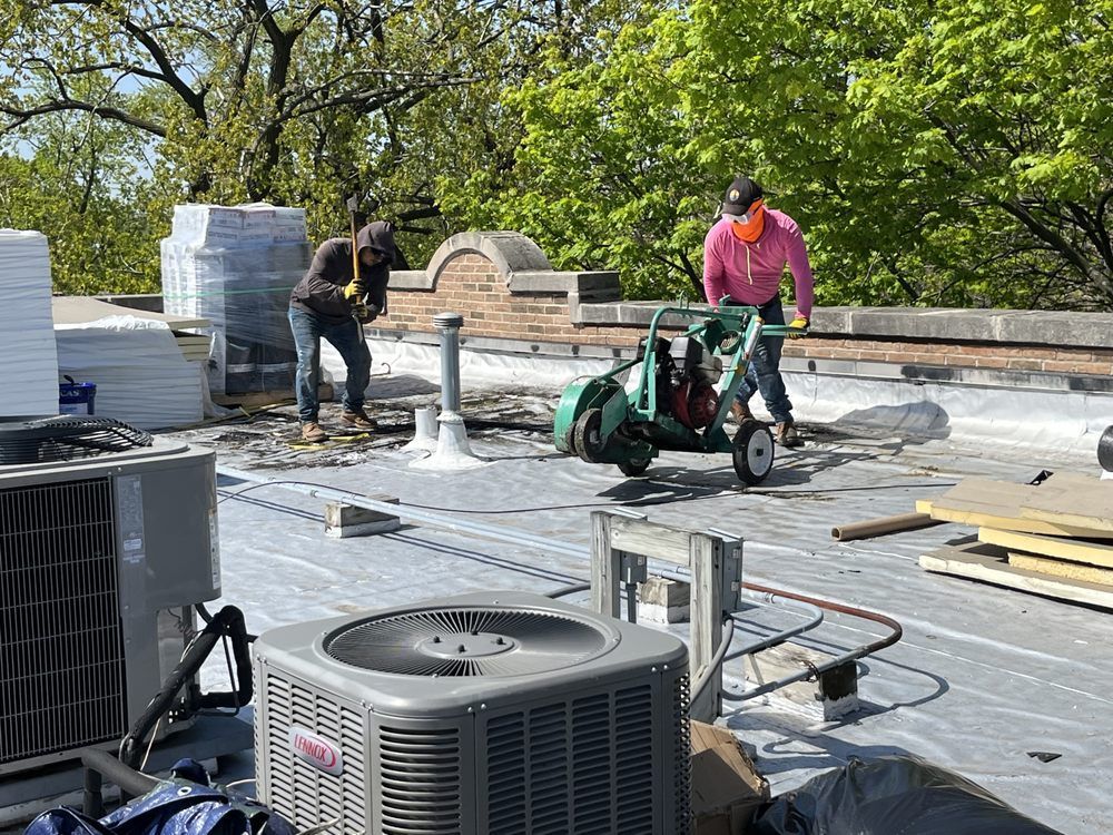 Workers on a rooftop installing equipment, with HVAC units and tools in the foreground.