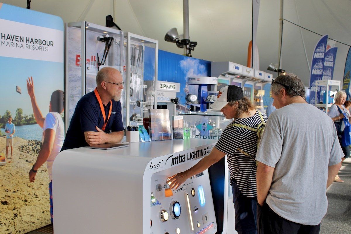 Marina employee speaking with boat show attendee