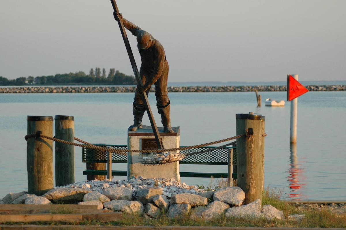 Statue of waterman with harbor in background