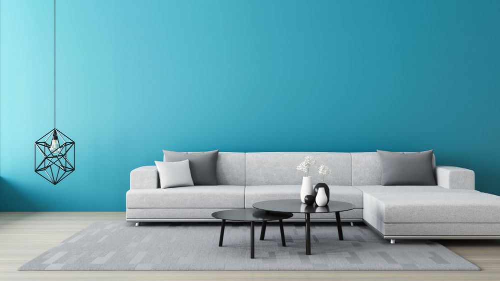 A Living Room With a Couch, Two Coffee Tables, and a Blue Wall — Clean Right Carpet Cleaning In Port Macquarie, NSW