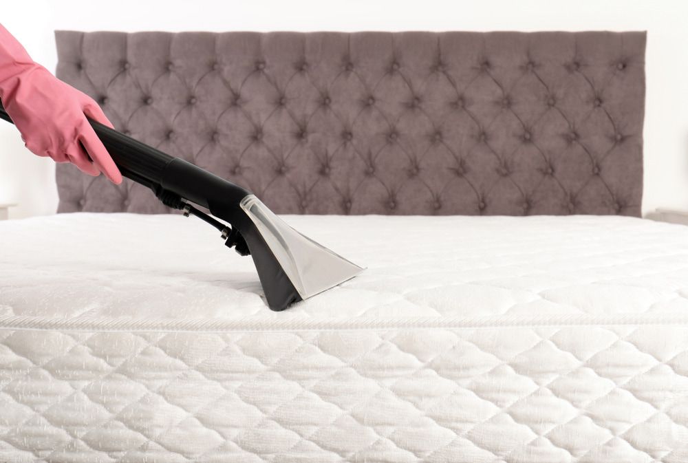 A Person is Cleaning a Mattress With a Vacuum Cleaner — Clean Right Carpet Cleaning In Port Macquarie, NSW