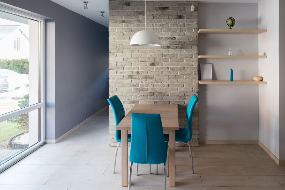 A Dining Room With a Table and Chairs and a Brick Wall — Clean Right Carpet Cleaning In Port Macquarie, NSW