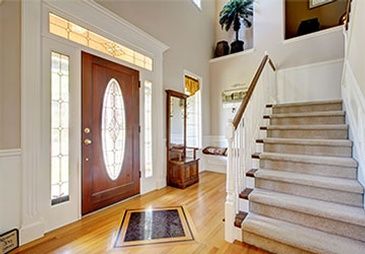 A hallway with stairs leading up to the second floor of a house.